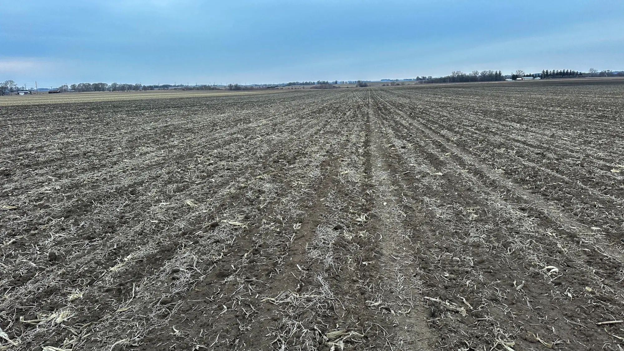 a photo of a bird's eye view of Cerro Gordo County, Iowa farmland. The sky is blue and cloudy.